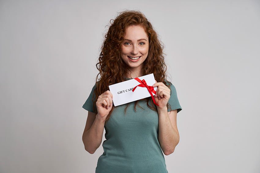 زن شادی که کارت هدیه در دست دارد
